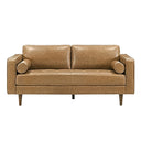 Front view of a mid-century modern tan genuine leather loveseat featuring square track arms, two plush back cushions, a tufted bench seat cushion, two cylindrical bolster pillows, and tapered dark wood legs against a white background.

