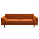 Casey mid-century modern burnt-orange velvet upholstered sofa featuring a button-tufted back, matching cylindrical bolster pillows, and tapered dark wood legs on a white background.