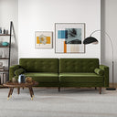 Casey tufted back olive-green velvet upholstered sofa with cylindrical bolster pillows and tapered wood legs, styled in a bright modern living room with wall art and an arched floor lamp.