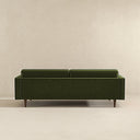 Back view of the Casey tufted back olive-green velvet upholstered sofa with tailored rear panel and tapered dark wood legs.