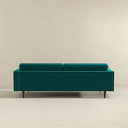 Back view of the Casey tufted back teal velvet upholstered sofa with tailored rear panel and tapered dark wood legs.