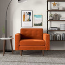 Casey burnt orange velvet armchair with button-tufted back cushion and tapered wooden legs in a modern living room setting