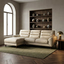 Chiara 97-inch cream genuine leather L-shaped sectional sofa featuring a left-facing chaise, channel-tufted backrest cushions, and tapered wooden legs set on a green rug in a warm, modern living room.