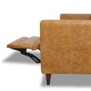 Side profile of a tan leather electric reclining sofa featuring the textured leather armrest, tapered dark wooden leg, and extended padded footrest supported by a black metal mechanism against a white background.