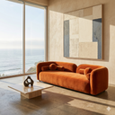 Modern living room with an orange sofa, abstract mirror, and view of the ocean.
