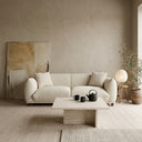 Elena 89" mid-century modern cream boucle sofa in a minimalist Japandi living room, featuring a travertine stone coffee table with a black teapot, a large beige abstract painting, and a round paper lantern lamp on a wooden stool.