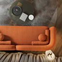 Top view of the Elissa 93-inch Japandi burnt orange boucle sofa featuring a curved, low-profile design and matching spherical pillows in a minimalist living room. The modern rust-colored couch is set on a gray shag rug next to a dark coffee table and a floor lamp.