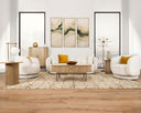 The Ellie linen sofa and matching swivel armchairs styled in a luxurious modern living room with abstract art, a geometric rug, and a city view.