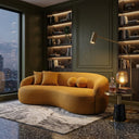 Modern Enzo 89 Japandi curved sofa in gold boucle fabric, styled in a luxury living room with dark green paneled walls, backlit bookshelves, and a marble side table.