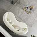 Top view of the Enzo 89-inch Japandi ivory bouclé curved sofa with two matching square throw pillows featuring the curvature of sofa and two round sphere accent pillows in a minimalist living room.