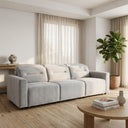 Franca 107 Light Grey Velvet Power Slider Sofa in a bright, minimalist living room with light oak wood floors, a round wooden coffee table, and a potted fiddle-leaf fig plant.