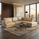 Gamila 110-inch beige genuine top-grain leather right-facing sectional sofa with chaise styled in a modern luxury living room with floor-to-ceiling city view windows, nested coffee tables, and an arched floor lamp.