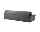 A rear three-quarter view of the black leather Giorgia sofa, showing the vertical seams on its back panel, the profile of a plush arm, and all four metal stiletto legs.