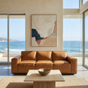 I will start by checking the permissions to read the image file.
I will request permission to read the image file.
I will view the image using the view_file tool.
Hanna 90 Mid-Century Modern tan genuine leather sofa in a modern minimalist living room with floor-to-ceiling windows showing a scenic ocean view, featuring a travertine coffee table and abstract wall art.