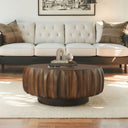 Wooden coffee table in front of a white tufted sofa with decorative pillows.