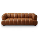 Jess 90 Mid-Century Modern cognac genuine leather sofa featuring a plush, low-profile design with vertical channeling, rounded arms, and short wooden legs, isolated on a white background.
