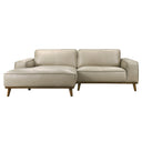 Front view of the Katia 98-inch left-facing sectional sofa in beige leather, featuring wide track arms, piped cushions, a spacious left-side chaise lounge, and a dark wood base with angled tapered legs against a white background.