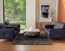 Modern living room with black sofas, a coffee table, and decorative elements.