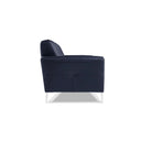 A side view of a dark blue contemporary modern leather sofa with buttonless tufting and chrome metal legs in a white back ground.