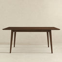 Front view of the Leroy 63-inch rectangular dining table in dark walnut wood, featuring a beveled tabletop and four slightly angled, tapered legs against a textured beige background.
