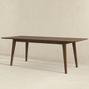 Leroy 87-inch mid-century modern rectangular dining table in rich brown walnut wood, featuring a slim beveled tabletop and four angled, tapered legs set against a neutral cream textured background.
