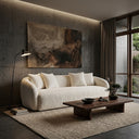 Modern minimalist living room featuring the Lina 84-inch ivory bouclé sofa with curved silhouette and matching throw pillows, a large abstract painting on a concrete panel wall, a low dark wood coffee table with a bonsai tree, a black floor lamp, and a textured beige rug.