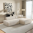 Modern cream corduroy right-facing sectional sofa with chaise lounge and matching throw pillows on a neutral area rug in a bright living room.