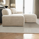 Melina cream corduroy right-facing sectional sofa with a chaise lounge and accent pillow on a neutral area rug in a bright, modern living room.
