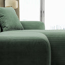 Close-up view of the Melina green corduroy sectional sofa, highlighting its textured ribbed upholstery, plush seat cushion, and matching pillow beside a bright window.