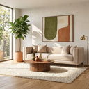 Nina 90-inch mid-century modern beige velvet sofa with vertical channel tufting on the arms, styled in a bright living room with a round wooden coffee table, fiddle leaf fig plant, large abstract wall art, and a brass floor lamp.