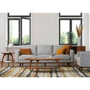 A gray upholstered Olwyn Sofa with a full wood base and wide track arms, presented in a living room set.