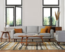 A gray upholstered Olwyn Sofa with a full wood base and wide track arms, presented in a living room set.