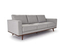 A gray upholstered Olwyn Sofa with a full wood base and wide track arms, presented against a white background.