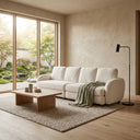 Pina 115 cream bouclé sofa in a minimalist, modern living room, styled with a sage green throw blanket, a wooden coffee table, a black floor lamp, and large windows looking out onto a Japanese Zen garden.