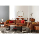 Modern living room with brown leather sofa, coffee table, and decorative items.