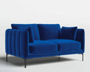 A dark navy velvet Roman loveseat shown in a minimalist white room, styled with a small black side table and a hanging glass pendant light.