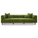 Modern Rosa 103 green velvet three-seater sofa with a wooden base and legs, featuring matching square and rectangular velvet throw pillows, isolated on a white background.