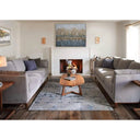 Living room with gray sofas, wooden coffee table, and fireplace.
