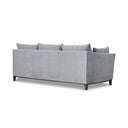 back side of a gray upholstered Taylor Sofa with subtly curved arms, a solid European beech hardwood base, and tapered dark brown legs.